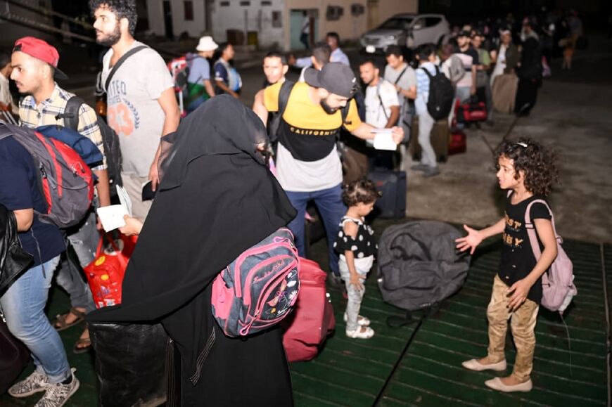 People board a passenger ferry as they evacuate from Port Sudan on April 25, 2023