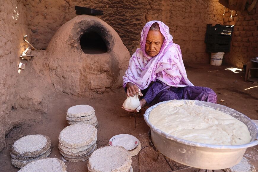 Naamat Jabal Sayyid Hasan, 75, bakes bread for people fleeing the fighting as they pass through Wadi Halfa near Sudan's border with Egypt