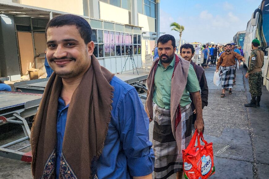 A Yemeni rebel fighter beams at the cameras as he prepares to board a flight for the rebel-held capital Sanaa as part of an exchange involving hundreds of prisoners