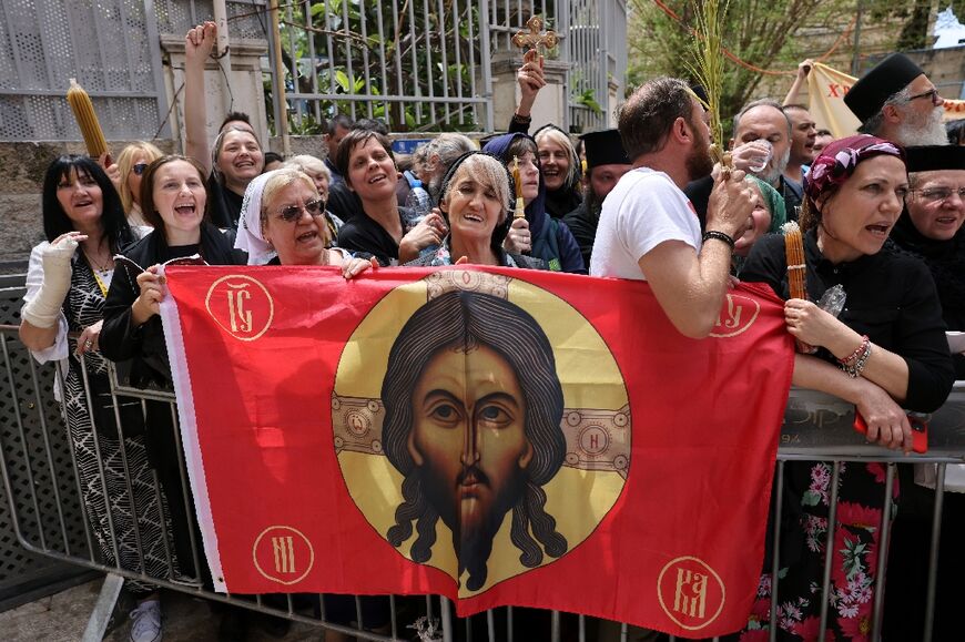 Christians wait behind a barrier set up by Israeli security forces in Jerusalem's Old City