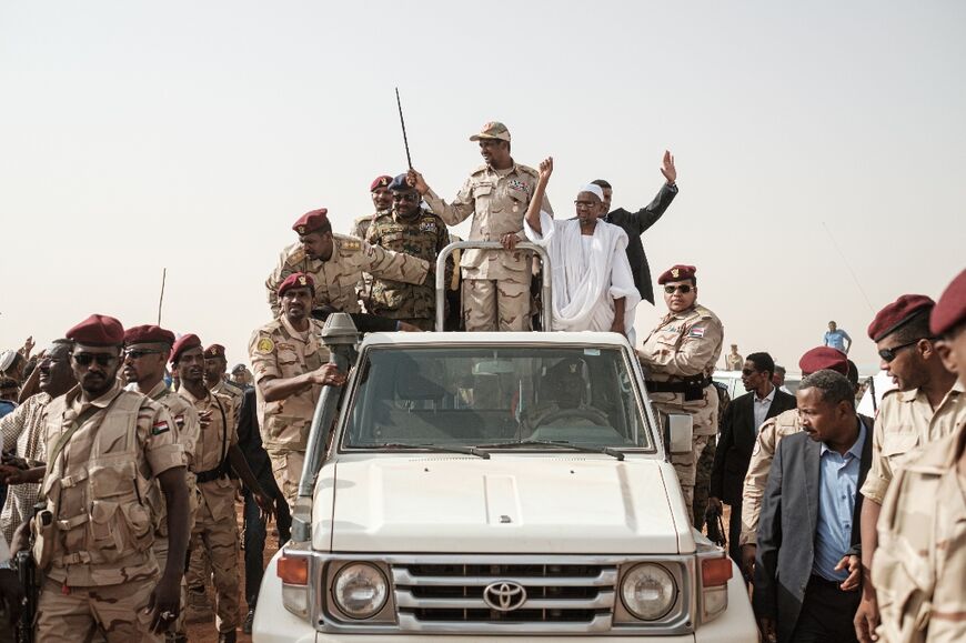 Mohamed Hamdan Daglo waves a baton to supporters in 2019