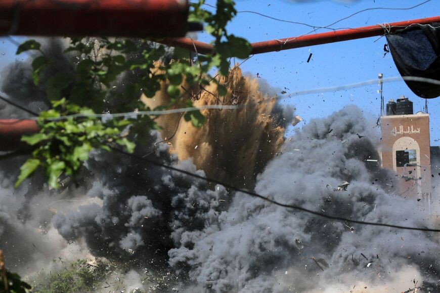 Smoke and debris fly over a building hit by an Israeli air strike in Beit Hanun in the northern Gaza Strip 