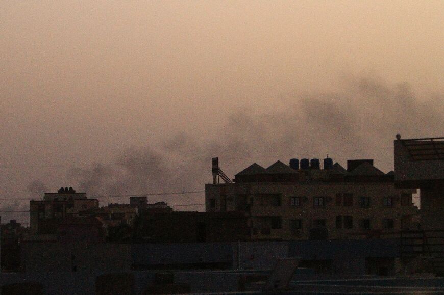 Smoke billows behind buildings in southern Khartoum -- mediators say both warring sides have violated the week-long truce