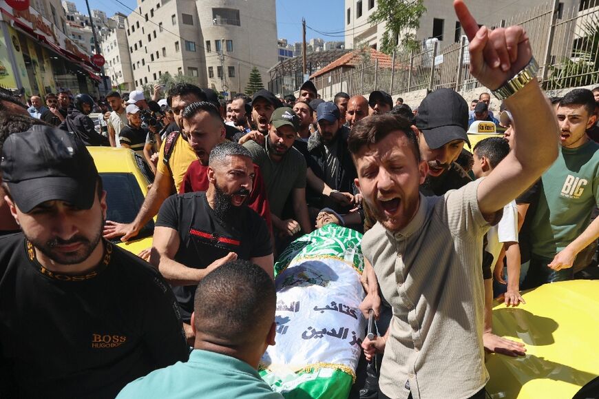 Palestinian mourners carry the body of one of three men shot dead by Israeli security forces during a raid, at the Rafidiya hospital in the occupied West Bank city of Nablus, on May 4, 2023