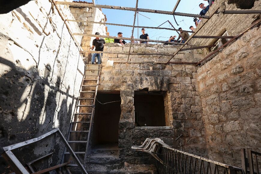 Palestinians inspect the site where three men were killed during an Israeli raid in the occupied West Bank city of Nablus on May 4, 2023