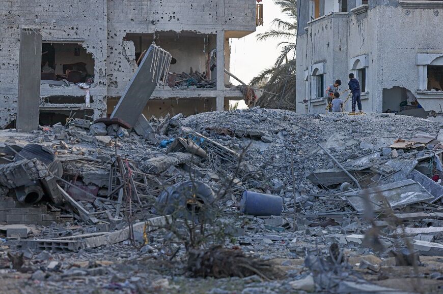 Palestinians inspect the rubble of a residential building flattened by an Israeli air strike in Deir al-Balah in the central Gaza Strip