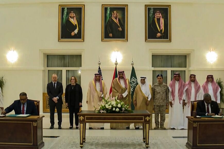 This screen grab from the Saudi TV channel Al-Ekhbariya, shows representatives of Sudan's army and the paramilitary Rapid Support Forces (RSF) signing an agreement in Jeddah, on Thursday