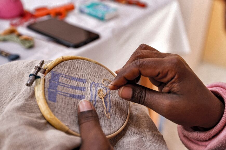 A worker sews a pattern of ancient Egyptian hieroglyphs on a cloth at the Malaika Linens factory 