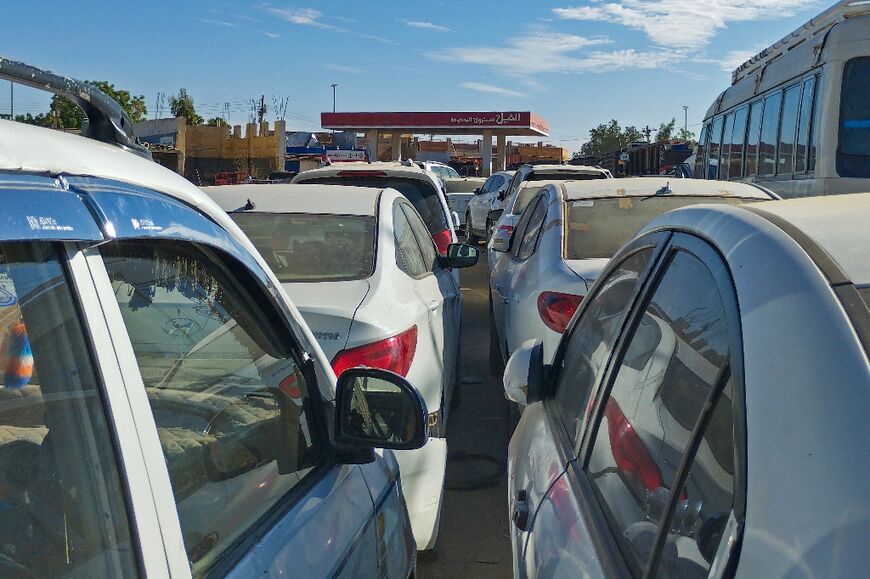 Motorists line up for scarce fuel at a petrol station in Khartoum 