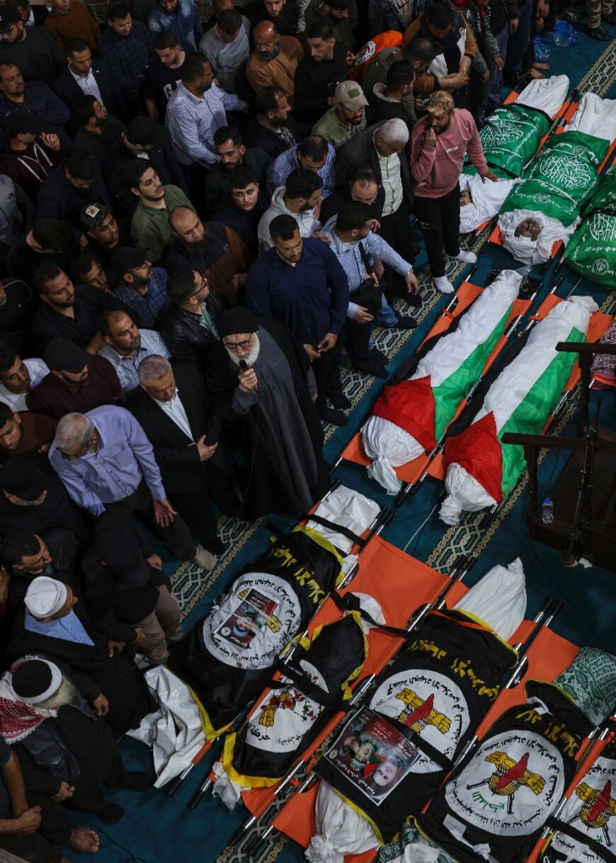 A Muslim cleric leads the prayer during a group funeral in Gaza City for people killed in Israeli air raids on the Palestinian territory early on May 9, 2023