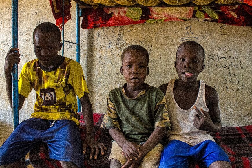 Children sit together on a bunk in a camp for displaced civilians 120 kilometres (80 miles) south of the battleground Sudanese capital Khartoum