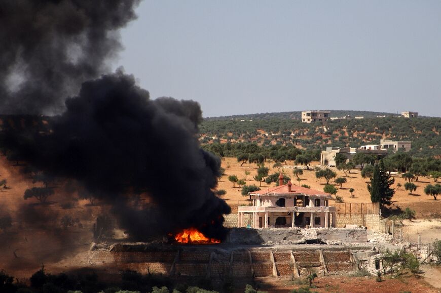 A plume of smoke rises from a building following reported Russian air strikes on Syria's northwestern rebel-held Idlib province