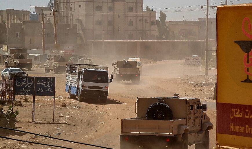 Sudanese army armoured vehicles drive in Khartoum, after paramalitaries seized the Central Reserve police headquarters in the city's south