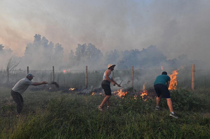 Residents extinguish a fire in Algeria's northwestern coastal town of Tabarka