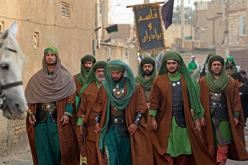 Performers parade through the streets of Noosh Abad