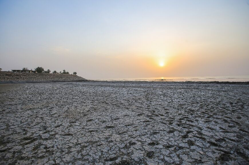 To get to the water, visitors must walk through foul-smelling mud that was once submerged under the lake surface