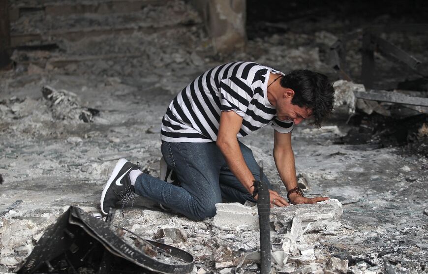 An Iraqi man reacts on July 4, 2016 as he enters a building destroyed in the suicide blast a day earlier