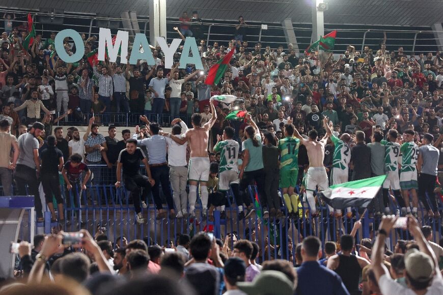 Home supporters celebrate with their team after the match