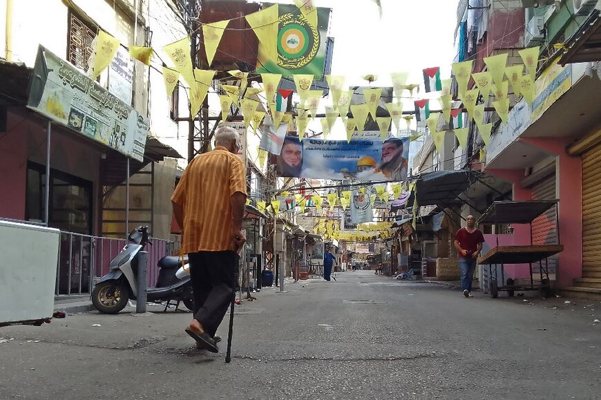 A resident walks past shops closed because of the fighting