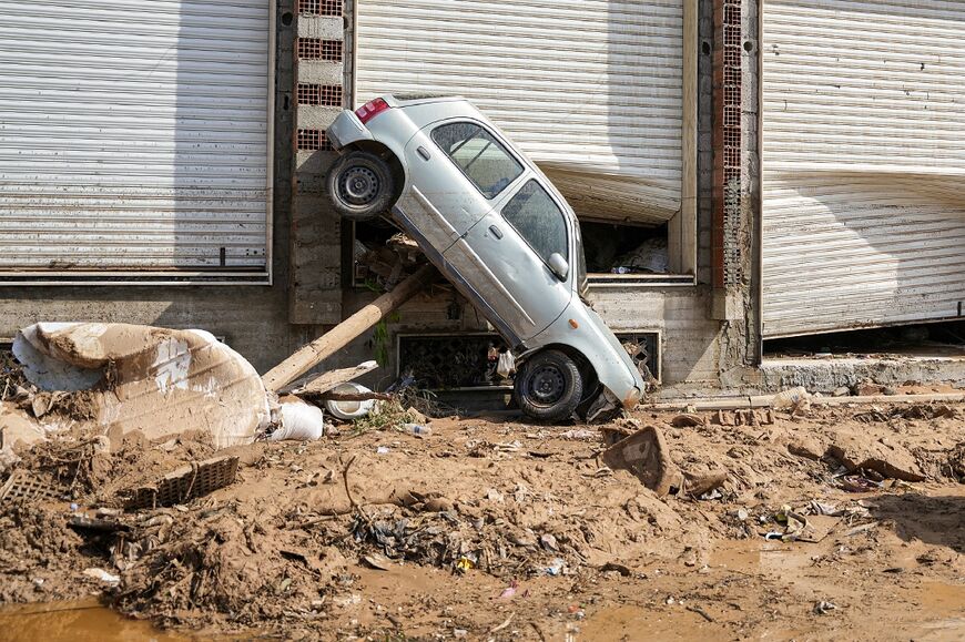 A car swept up against the side of a Benghazi building by the floodwaters