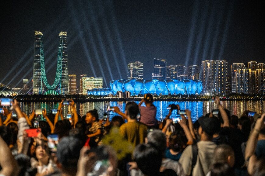 People gather to watch a light show from the
Hangzhou Olympic Sports Centre Stadium 