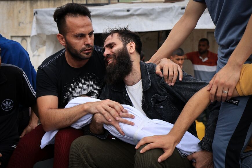 A father mourns his child killed in an Israeli strike on Khan Yunis in the southern Gaza Strip, before his burial on October 29, 2023