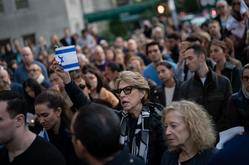 A person holds an Israeli flag as people attend a prayer service and candlelight vigil for Israel at Temple Emanu-El in New York City on October 9, 2023, after the Palestinian militant group Hamas launched an attack on Israel