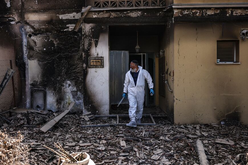 A volunteer of the Zaka emergency response team searches through the debris in Kibbutz Beeri near the border with Gaza on October 20, 2023