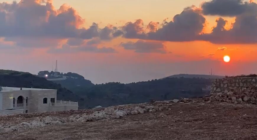 This grab taken from footage shot by AFP videographer Dylan Collins shows a flash of light (L) coming from an Israeli position the instant before the journalists were hit