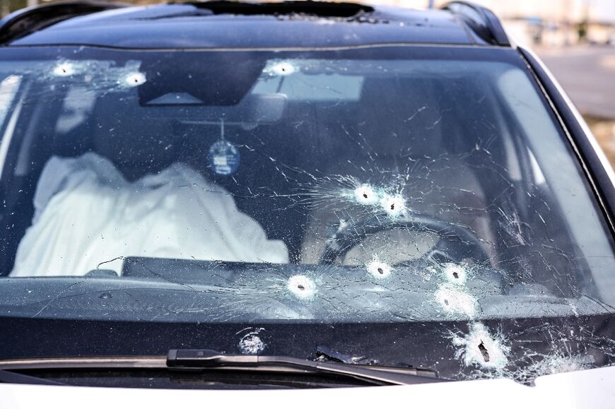 The body of a killed person lies covered inside a bullet-riddled car in the southern city of Sderot