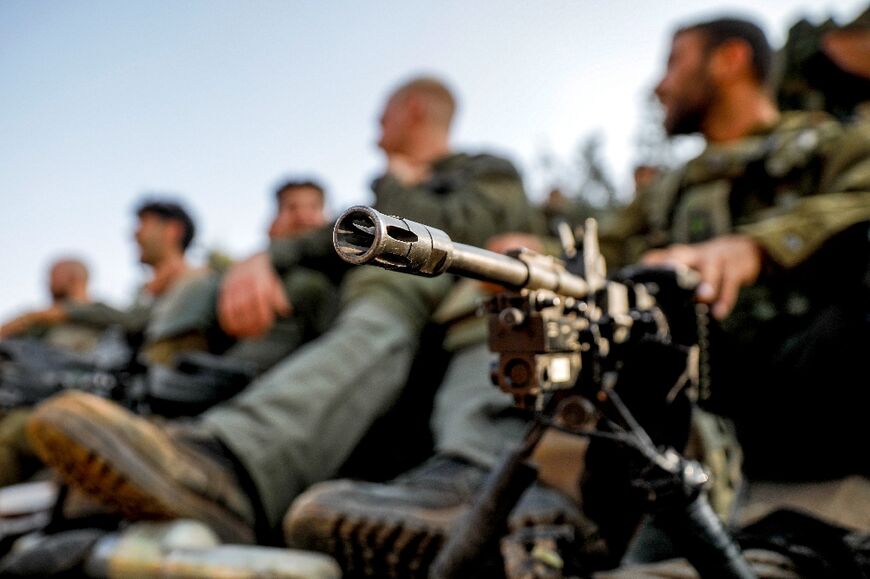 An Israeli soldier sits by a machine gun at a position in the upper Galilee region of northern Israel near the border with Lebanon 