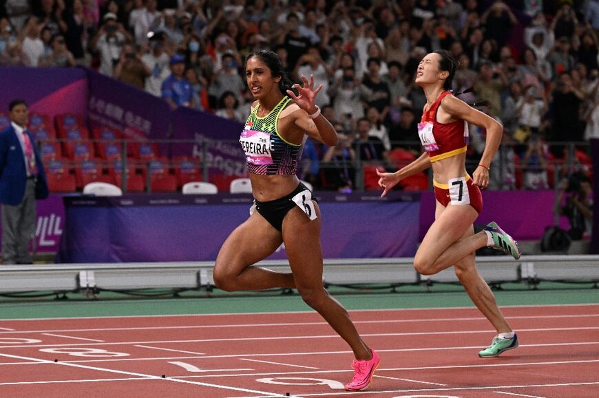 Singapore’s Shanti Pereira (L) crosses the finish line to win the Asian Games women's 200m final