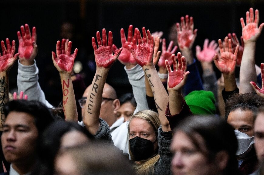 Protestors calling for a ceasefire in Gaza raise red-painted hands during a US Senate hearing in Washington, DC on October 31, 2023