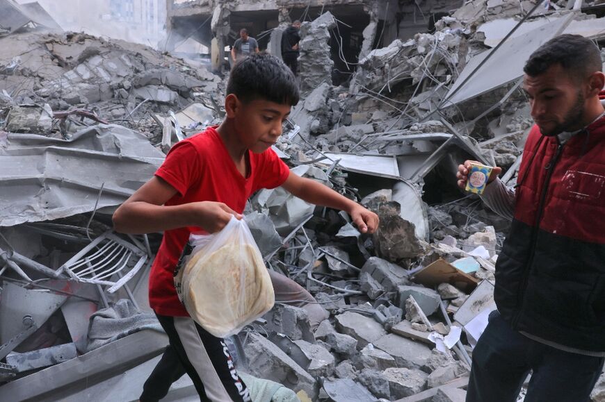 A Palestinian carries a bag of bread in Gaza which Israel has placed under siege 