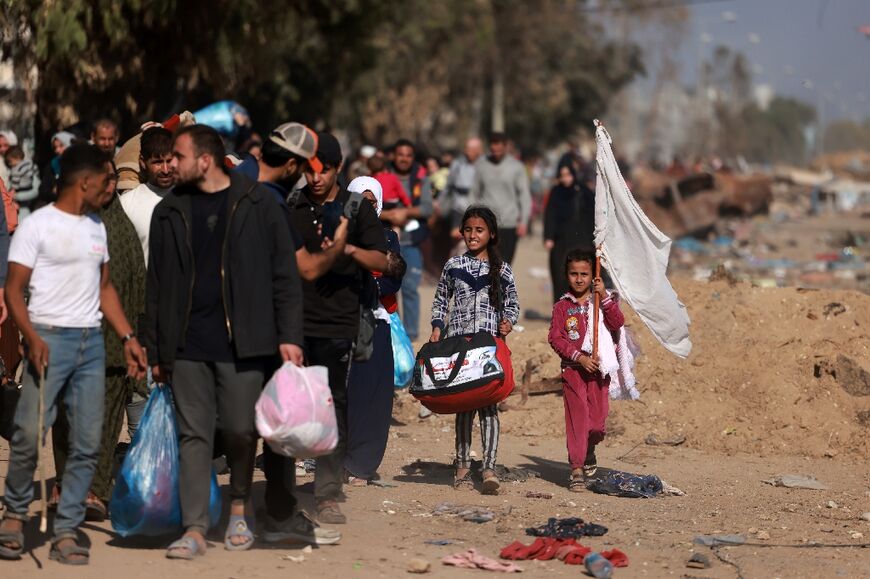 A child waves a white flag as her family joins hundreds of other Gaza civilians fleeing south through the battle lines of encircling Israeli troops 