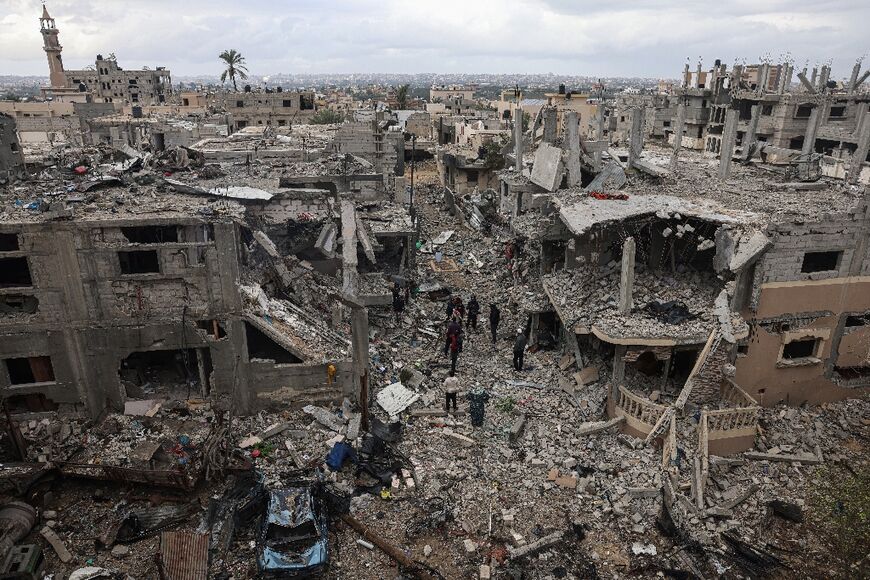 Palestinians inspect the destruction caused by Israeli strikes on their homes in the village of Khuzaa, near Abasan in the southern Gaza Strip