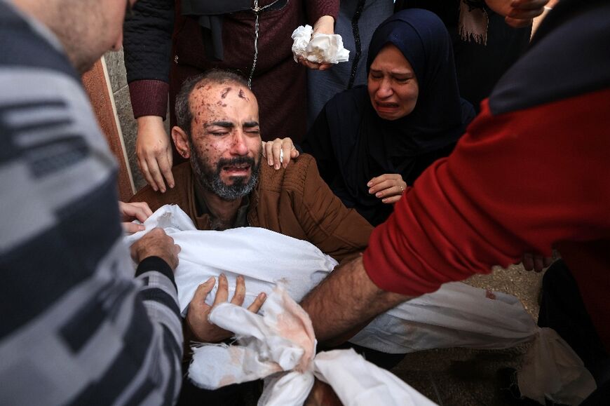 A Gazan couple with the body of one of their children, killed in bombardment of Khan Yunis in the southern Gaza Strip, on November 19, 2023