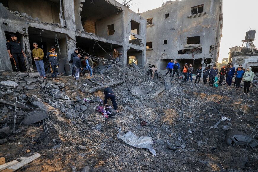 Rescuers look for survivors in the rubble of the Al-Agha family home following an Israeli strike in Khan Yunis on the southern Gaza Strip