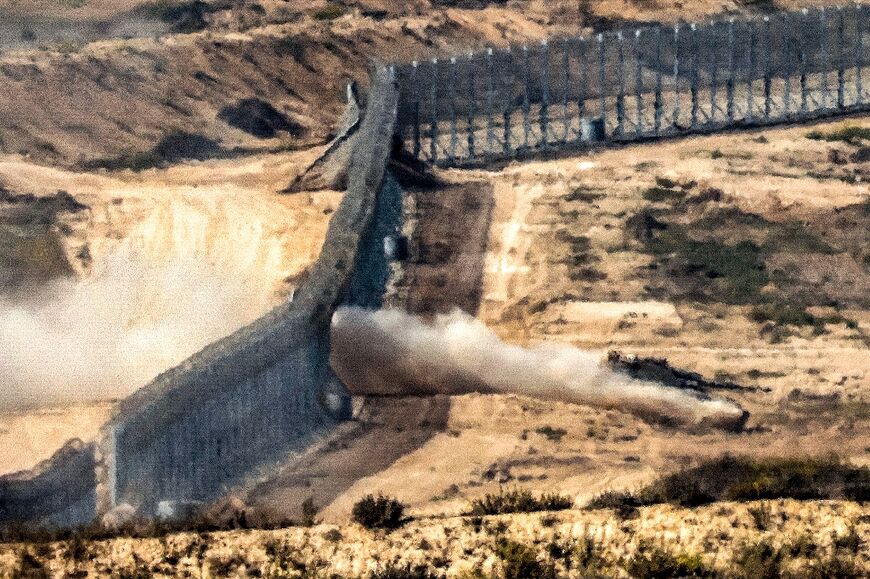 An Israeli army battle tank crosses a barbed wire fence at a position along the border with the Gaza Strip and southern Israel 