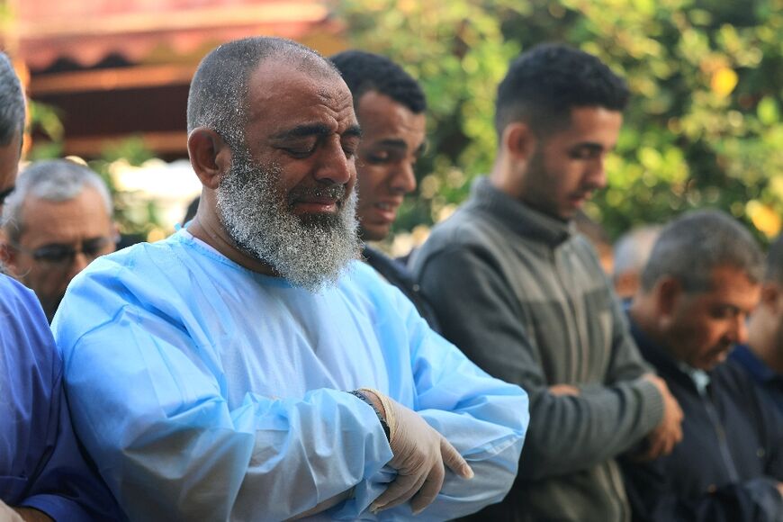 Palestinian men pray for war victims in Khan Yunis in the southern Gaza Strip on November 9, 2023