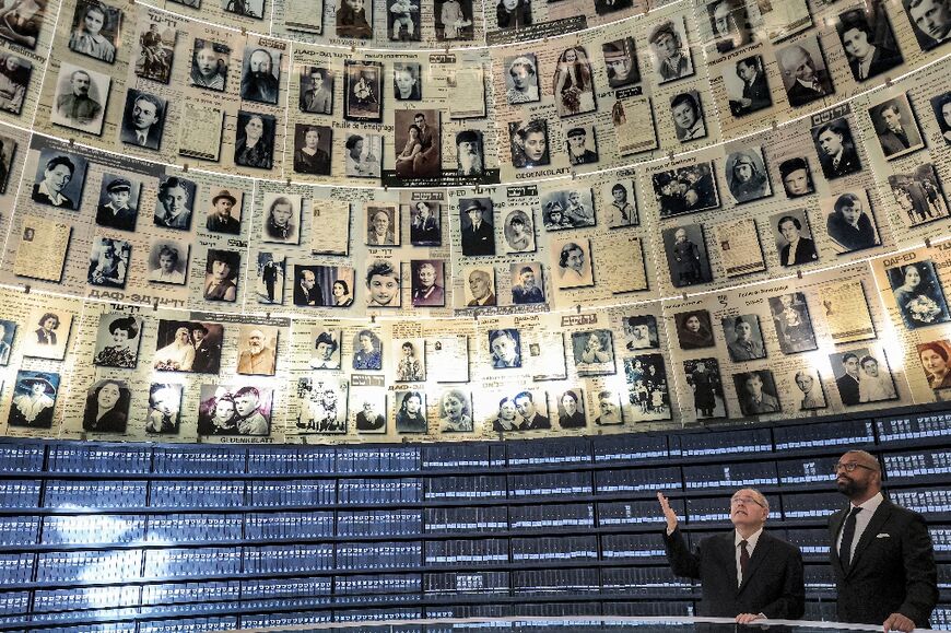 Yad Vashem Chairman Dani Dayan escorts Britain's then foreign minister James Cleverly in the Hall of Names at the memorial centre in Jerusalem on September 11, 2023