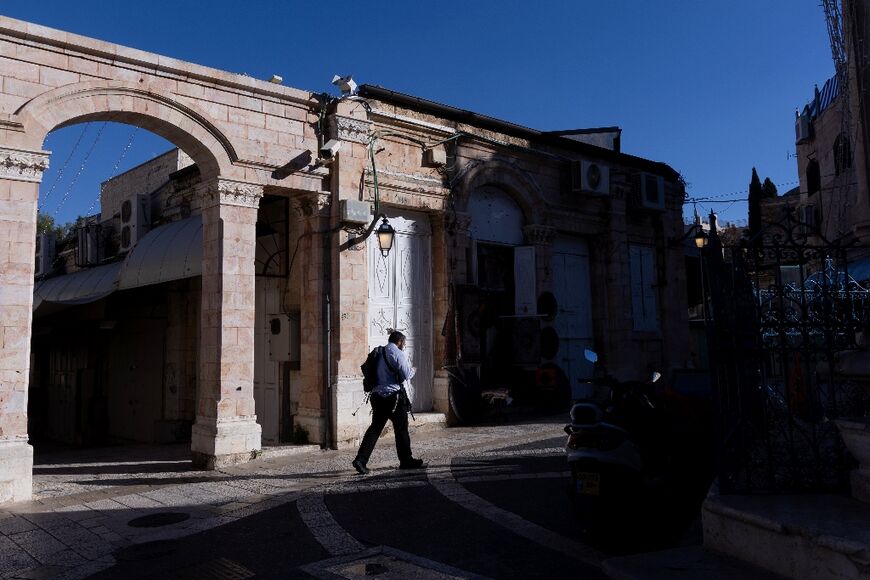 An armed Jewish man walks in Jerusalem’s Old City on November 21