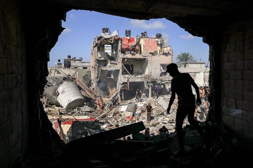 A Palestinian stands in front of a bombed-out building in Khan Yunis