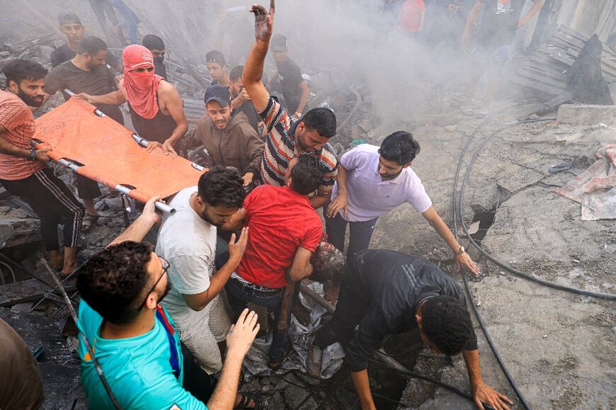 Palestinians recover the body of a child from the rubble of a building, in Khan Yunis on November 6, 2023, amid the ongoing battles between Israel and the Palestinian group Hamas