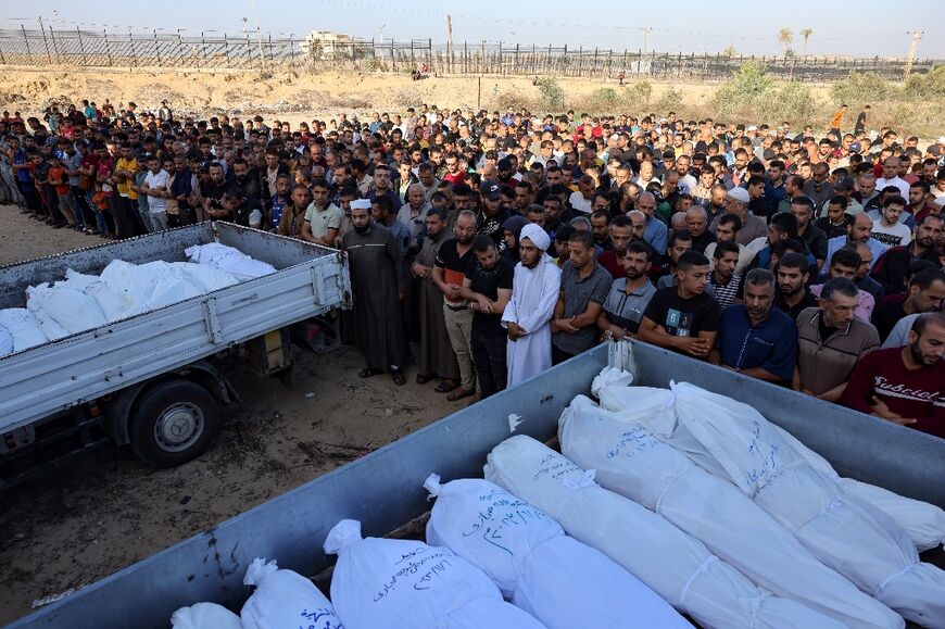 Palestinians pray near the bodies of people killed during the war in Gaza 