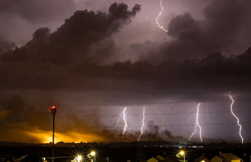 Flares are fired as lightening illuminates the sky during the Israeli military bombardment of the northern Gaza Strip