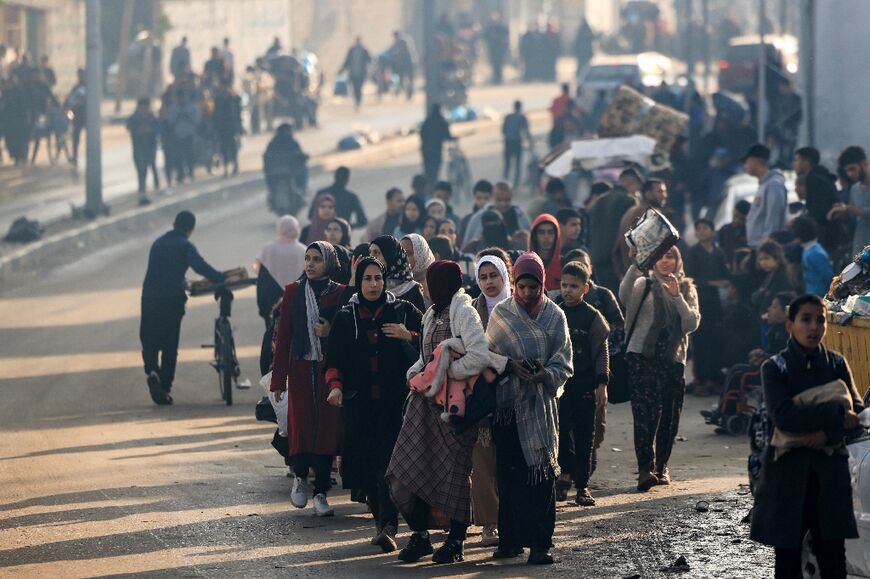 Palestinians walk toward safer areas following the resumption of Israeli strikes on Rafah in the southern Gaza Strip