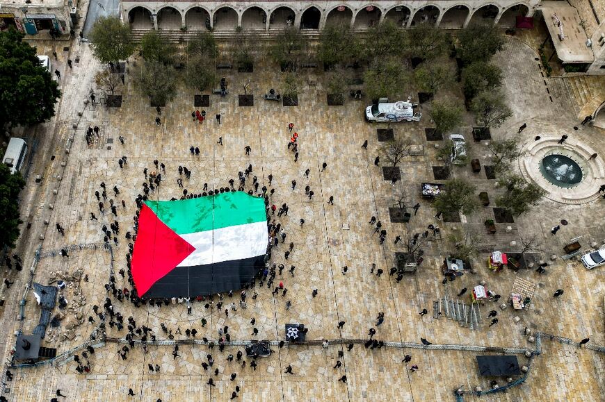 A giant Palestinian flag is unfurled outside the Church of the Nativity in the biblical city of Bethlehem in the occupied West Bank on Christmas Eve