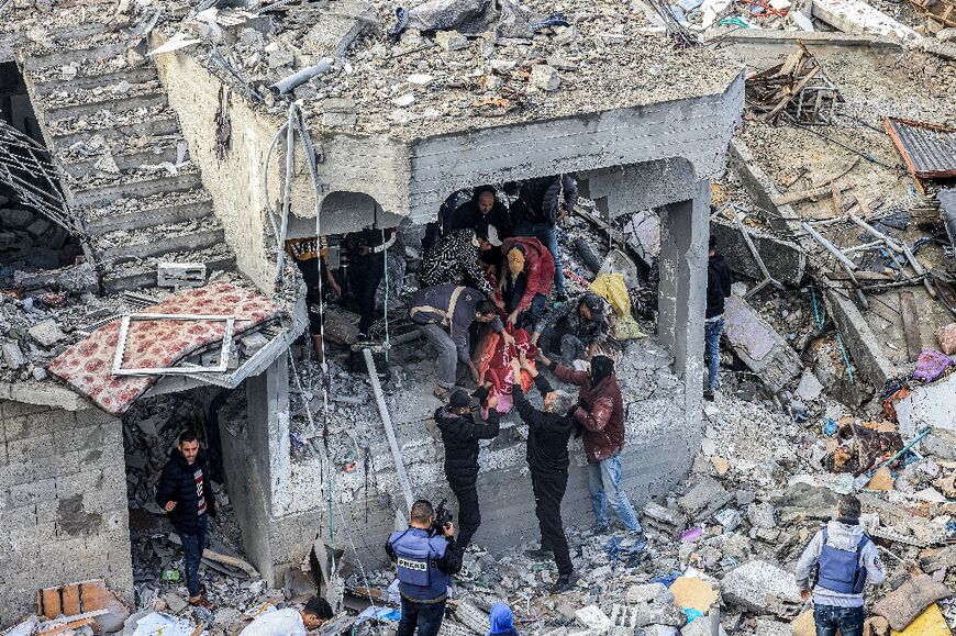 Men recover the body of a victim killed in the Al-Maghazi camp strike