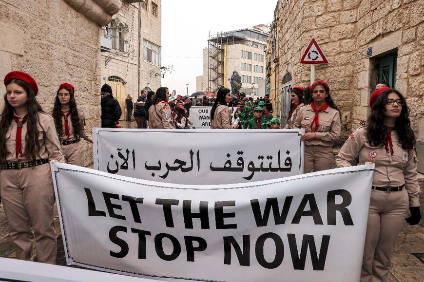 Palestinian youths of the scouting movement hold up banners calling for an end of the conflict in the Gaza Strip between Israel and Hamas